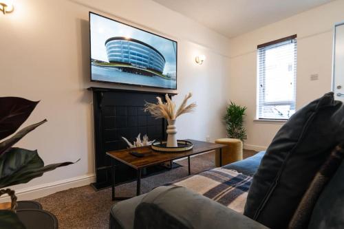 a living room with a tv on a wall at Finnieston 1-Bed - Walk to Hydro & Bars - Sleeps 2 in Glasgow