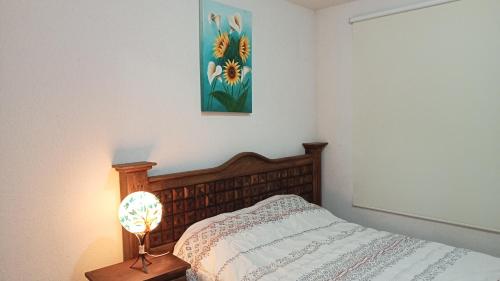 1 dormitorio con 1 cama y una pintura en la pared en Confortable casa de descanso para fin de semana, en Tlayecac