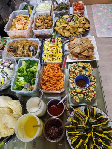 a table with many trays of food on it at Bangdigareum B&B in Seogwipo