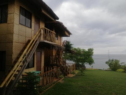 a building with a staircase next to the ocean at Almare Guest House Siquijor in San Juan