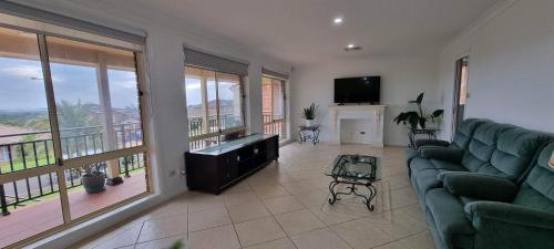 a living room with a couch and a flat screen tv at Shellharbour. Ocean, lake and mountain view in Shellharbour