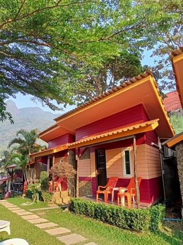 a red house with chairs in front of it at Cliff View Bungalows in Ko Chang