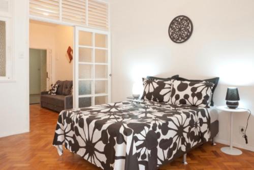 1 dormitorio con 1 cama en blanco y negro y 1 sofá en IPANEMA - EXCELENTE APARTAMENTO NA MELHOR LOCALIZAÇÂO, 2 quadras da praia!!!, en Río de Janeiro