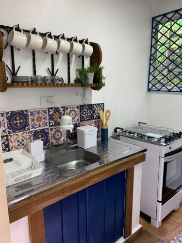 eine Küche mit Spüle und Herd in der Unterkunft Petite Maison - Dona Belandira in Campos do Jordão