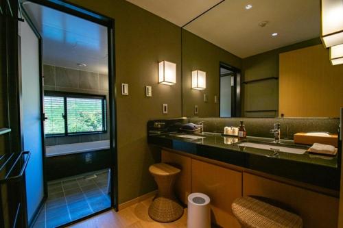 baño con lavabo y espejo grande en Senomoto Kogen Hotel en Minamioguni