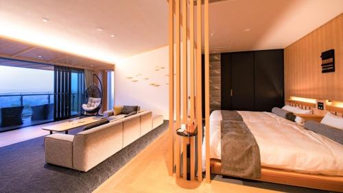 a bedroom with a bed and a desk and a couch at Senomoto Kogen Hotel in Minamioguni