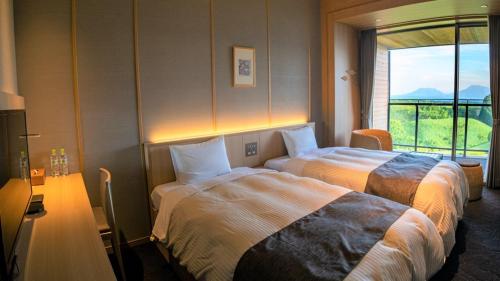 a hotel room with two beds and a window at Senomoto Kogen Hotel in Minamioguni