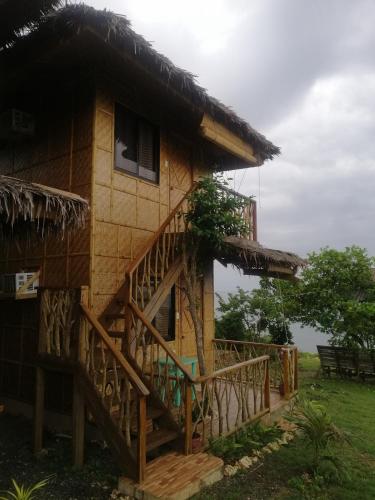 a house with a staircase leading up to it at Almare Guest House Siquijor in San Juan