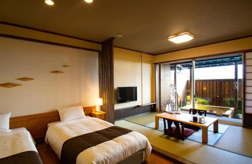 a hotel room with two beds and a television at Senomoto Kogen Hotel in Minamioguni