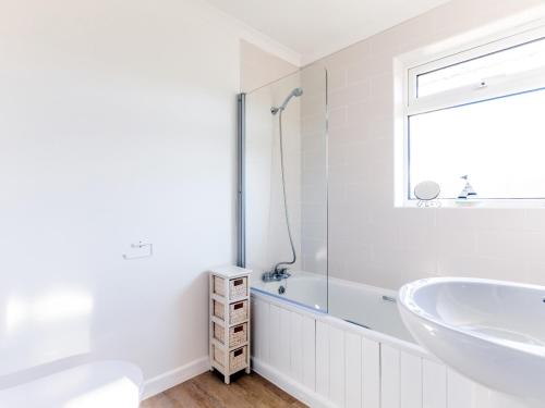 Un baño blanco con bañera y lavabo. en Little Sailing, en Padstow