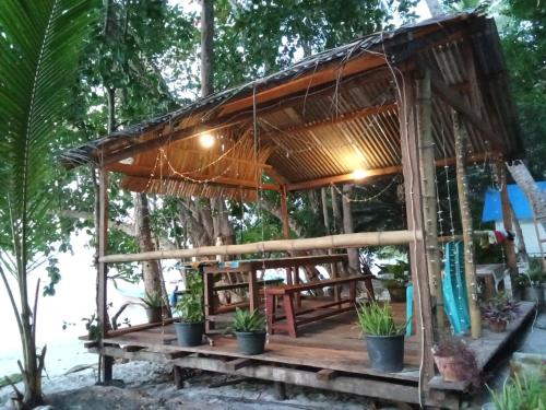 a bamboo house with a bench and plants on a table at Biryei Homestay in Pulau Birie