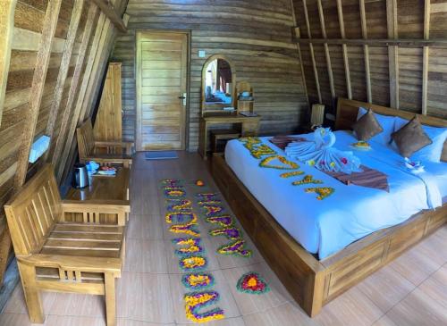 a bedroom with a bed and a table and a desk at Kubu Penida Villa in Nusa Penida