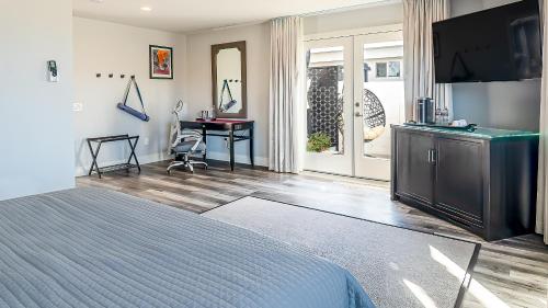 a bedroom with a bed and a television and a desk at Onsen Hotel and Spa in Desert Hot Springs
