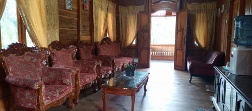 a living room with red couches and a table at Talaga Tomohon Home Stay and Fishing Pond in Tomohon