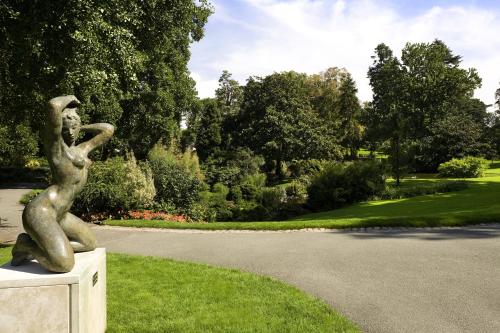 a statue of a woman sitting on the grass at Mercure Angers Centre de Congrès in Angers
