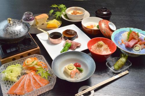 a table with plates of food and bowls of food at Hotel Shinanoji in Nagano