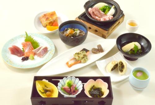 a white table with plates of food on it at Hotel Shinanoji in Nagano