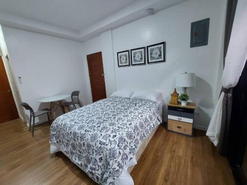 1 dormitorio con 1 cama y 1 mesa con lámpara en Regal425 Condotel, en Ángeles