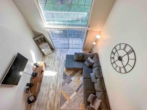 a living room with a couch and a clock on the wall at WOO LOFT- King Bed- Downtown BHM in Birmingham