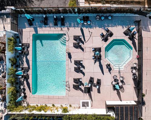 uma vista superior de uma piscina com cadeiras e mesas em Onsen Hotel and Spa em Desert Hot Springs