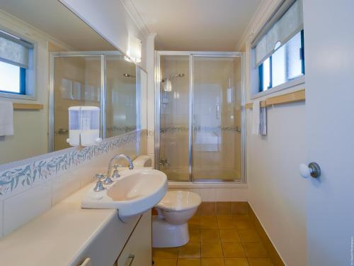a bathroom with a sink and a shower and a toilet at Boat Harbour Studio Apartments and Villas in Hervey Bay