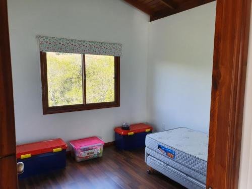 Habitación con 2 camas, ventana y suelo de madera. en Sierra y Sol, en Villa Serrana