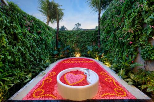 a bathroom with a heart shaped sink on a red carpet at Astera Luxury Resort & Spa Canggu by Ini Vie Hospitality in Canggu
