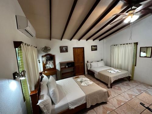 a bedroom with two beds and a television in it at Loma Real Hot Springs Bed & Breakfast in Fortuna
