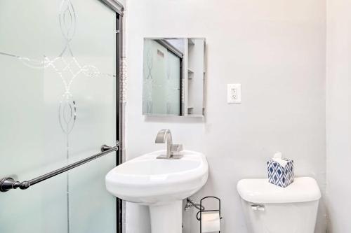 a white bathroom with a sink and a toilet at 4BR+Parking central townhouse walk to metro&shops in Washington, D.C.