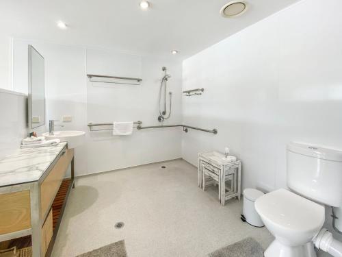 Blue on Blue Apartment 316 في خليج نيللي: حمام أبيض مع مرحاض ومغسلة