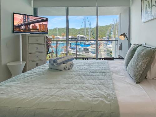 Blue on Blue Apartment 316 في خليج نيللي: غرفة نوم بسرير كبير مع إطلالة على المرسى