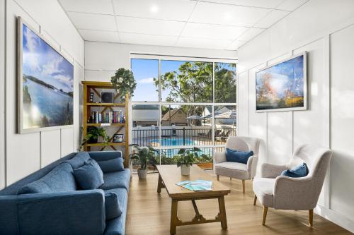 a living room with two blue couches and a table at Kiama Shores in Kiama