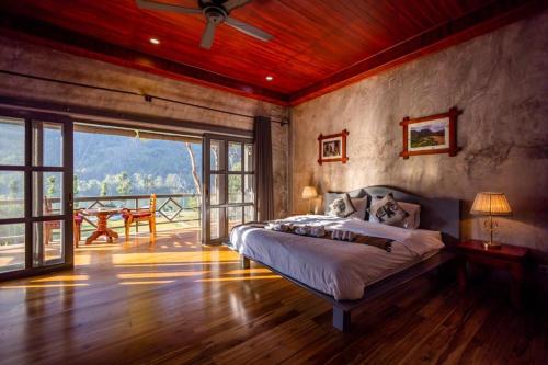 a bedroom with a large bed and a balcony at Resort Maison de nongkhiaw in Ban Ngoy-Nua