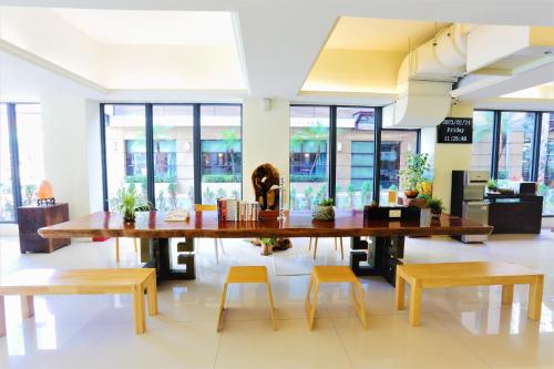 a large table and chairs in a room with windows at Huang Shin Business Hotel-Chung Kang in Taichung