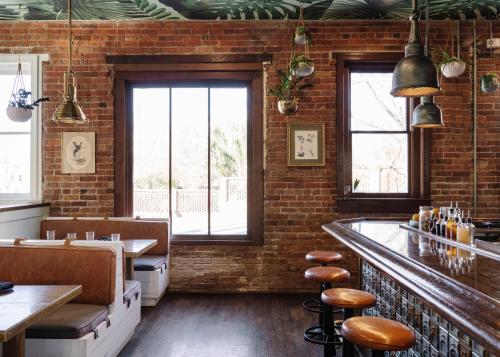 a restaurant with brick walls and a bar with stools at ARRIVE Wilmington in Wilmington