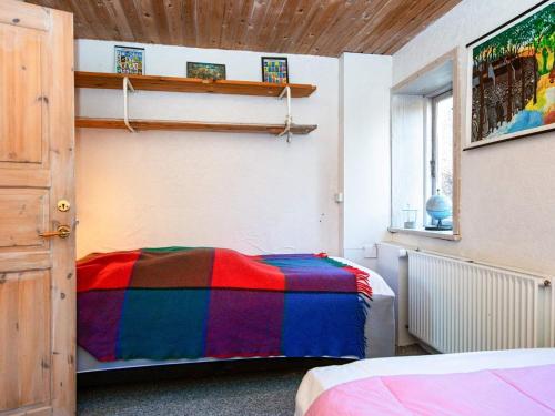ein Schlafzimmer mit einer bunten Decke auf einem Bett in der Unterkunft Holiday home Lemvig XLI in Lemvig