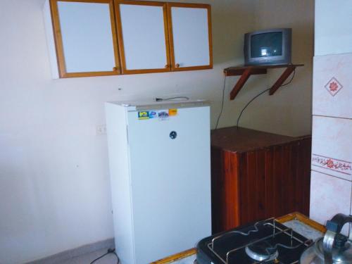 cocina con nevera blanca y TV en Departamento Mí Sueño en Ushuaia