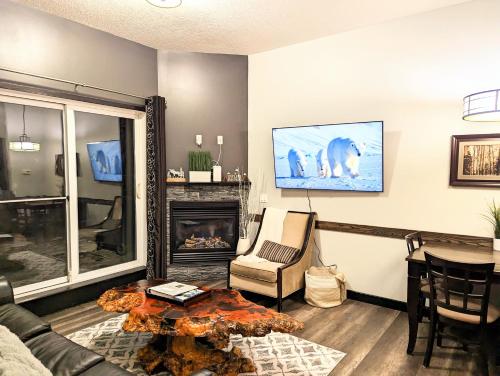uma sala de estar com um sofá e uma lareira em Canmore Mountain Retreat. Hot Tub, Pool, King Bed! em Canmore