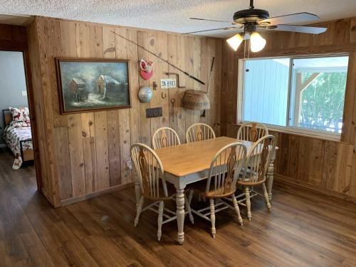uma sala de jantar com uma mesa de madeira e cadeiras em Clark Creek Ranch Cabin em Medina