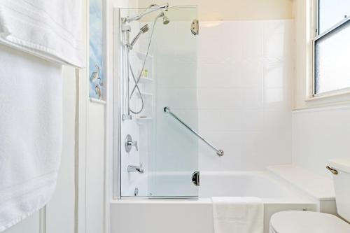 a bathroom with a shower with a glass door at Cornell Hotel de France in San Francisco