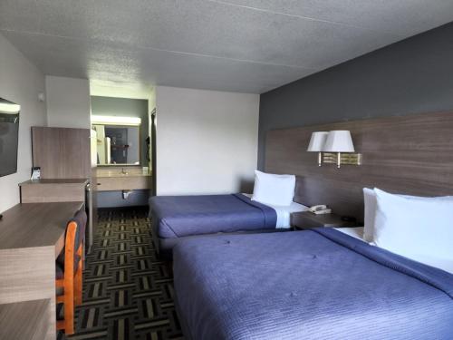 a hotel room with two beds with blue sheets at Relax Inn in Hendersonville