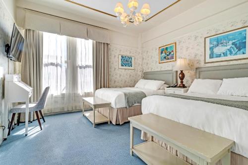 Cette chambre comprend deux lits et une télévision. dans l'établissement Cornell Hotel de France, à San Francisco