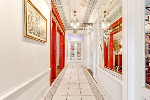 a hallway with red and white walls and a tile floor at Cornell Hotel de France in San Francisco