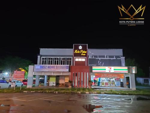 a building with a sign on it in a parking lot at Kota Putera Lodge in Jertih