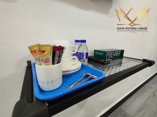 a shelf in a store with a tray with cups and drinks at Kota Putera Lodge in Jertih