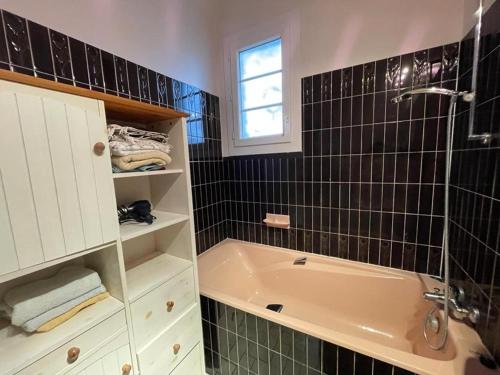 ein Badezimmer mit Badewanne und Waschbecken in der Unterkunft Villa landaise charmante pour 6 pers avec grand jardin - Capbreton - FR-1-413-211 in Capbreton
