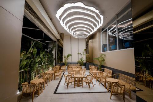 a restaurant with tables and chairs and a large chandelier at The Rangoon Hotel in Yangon