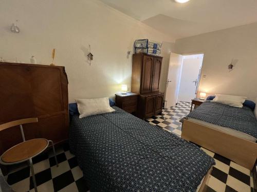 - une chambre avec 2 lits et un sol en damier dans l'établissement T4 1er ét. 3 ch, terrasse, 10m plage, parking - FR-1-701-59, à Valras-Plage