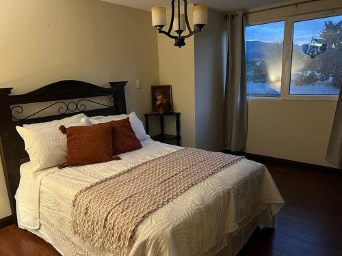 a bedroom with a large bed with a window at Vila Krista in Quetzaltenango