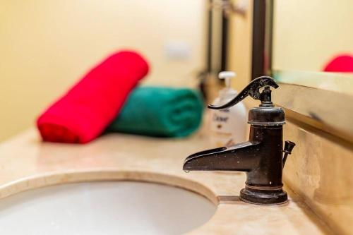 a bathroom sink with a faucet and a mirror at Villa Amor del Mar with Breathtaking View of Ocean & Jungle in Dominical